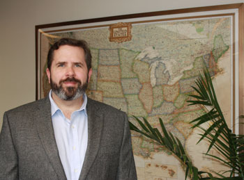 Greg Yetman standing in front of a map.