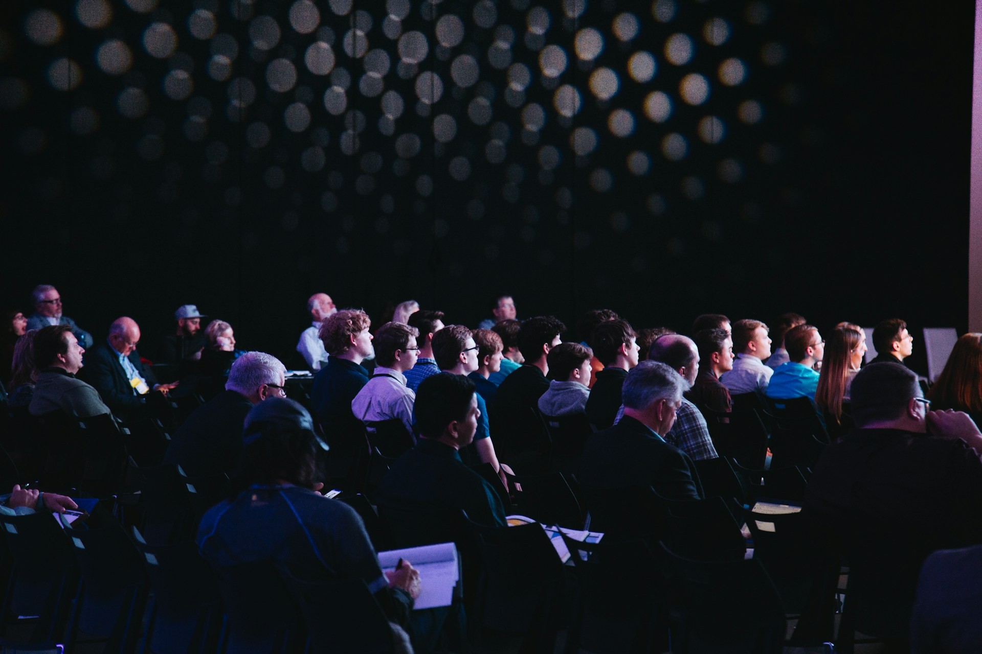 Crowd of people sitting on chairs inside room. Photo by Headway on Unsplash